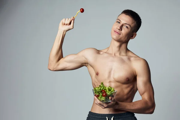 Hombre celebración placa de ensalada deportes alimentación energía culturista entrenamiento aislado fondo — Foto de Stock