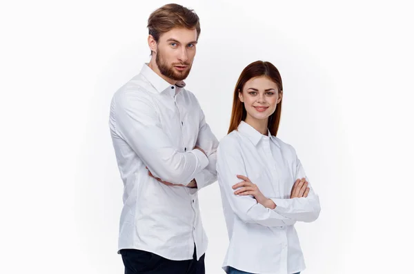 Um homem e uma mulher de camisas brancas com os braços cruzados estão atrás uns dos outros empregados no trabalho — Fotografia de Stock