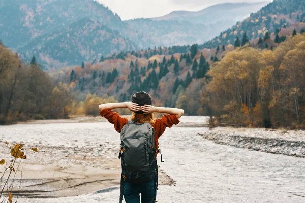 一个头戴毛衣帽 背包松驰在山中河岸的旅行者 高质量的照片 — 图库照片