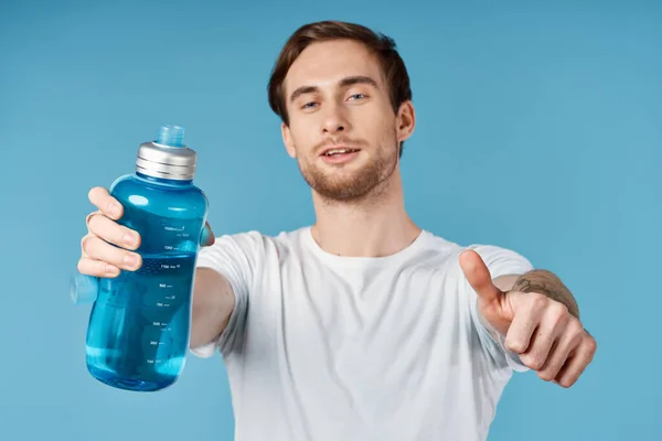 Uomo in bianco t-shirt bottiglia d'acqua dissetante vista ritagliata sfondo blu — Foto Stock