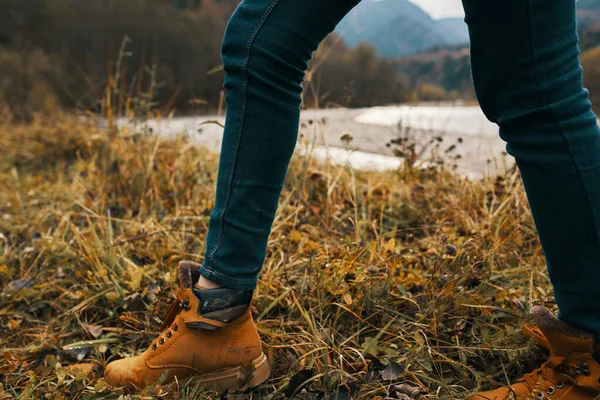 Frauenbeine in Stiefeln und Jeans über die Natur im Herbst in den Bergen — Stockfoto