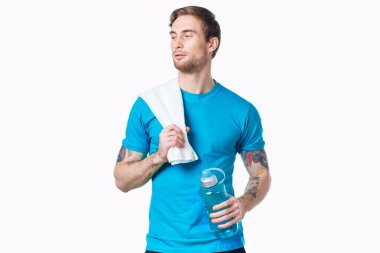 Elinde bir şişe su ve spor dövmesi olan yakışıklı bir adam.