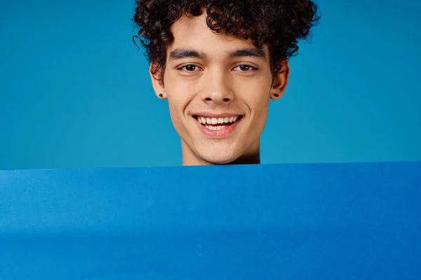 Uomo allegro con i capelli ricci poster blu primo piano — Foto Stock