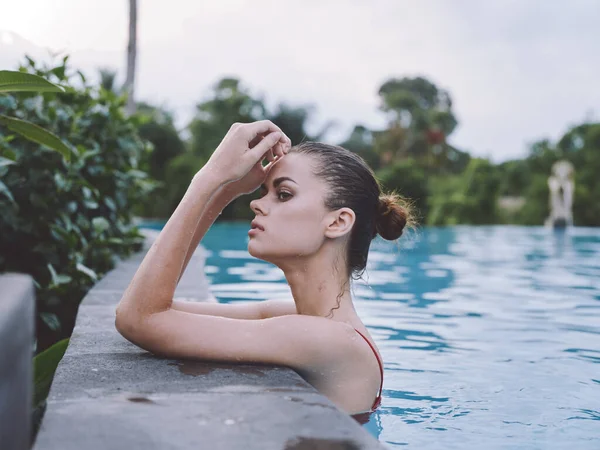 Bella donna Nuoto in piscina e costume da bagno rosso trasparente acqua hotel vacanza modello relax — Foto Stock