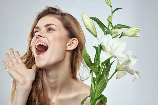 Femme émotionnelle avec des fleurs modèle printemps épaules nues peau claire — Photo