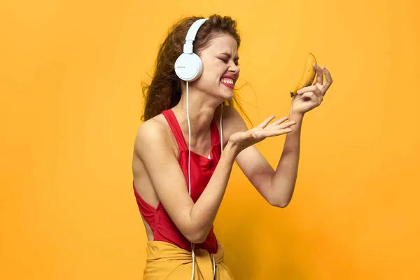 Mulher emocional usando fones de ouvido ouvir música close-up fundo amarelo — Fotografia de Stock