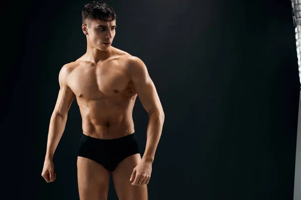 Hombre con desnudo muscular cuerpo en oscuro bragas culturista —  Fotos de Stock