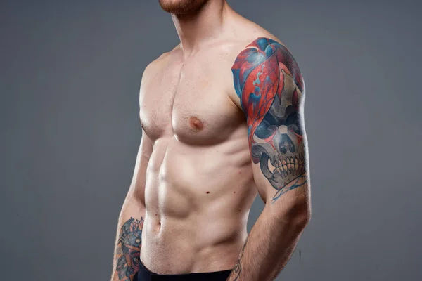 Man met tatoeages op zijn armen naakte romp oppompen buikspieren workout — Stockfoto