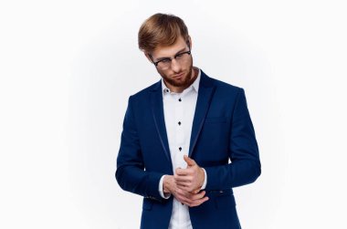 Klasik takım elbiseli sarışın adam ceketinin kollarını kırpıştırıyor.