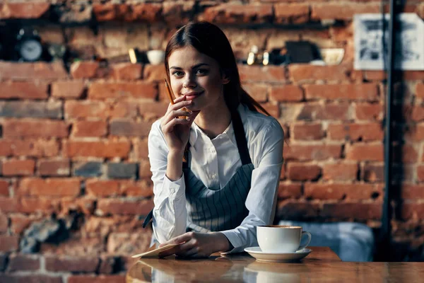 Mulher garçom em uniforme de café perto da mesa — Fotografia de Stock