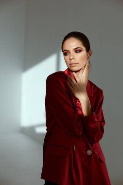 Parlak makyajlı esmer, yüzünün yanında el ele tutuşuyor.