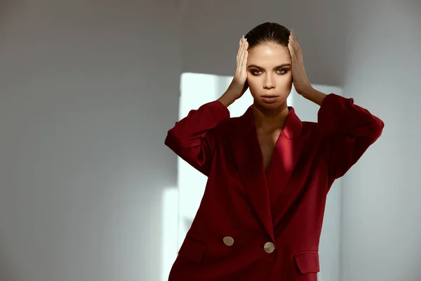 Mujer con sombras de ojos y peinado en su cabeza chaqueta roja fondo oscuro — Foto de Stock