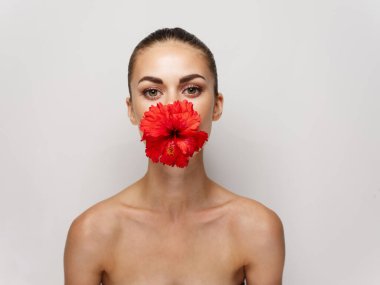 Çıplak omuzlu ve kırmızı çiçekli bir kadın.