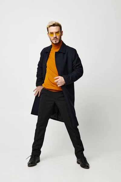 Чоловік в пальто і штани помаранчевий светр мода одяг модель весняний тренд окуляри — стокове фото