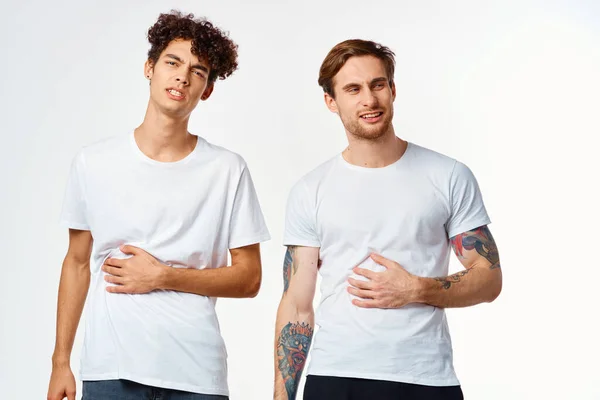 Emotivo due amici in t-shirt bianche sì divertente studio — Foto Stock