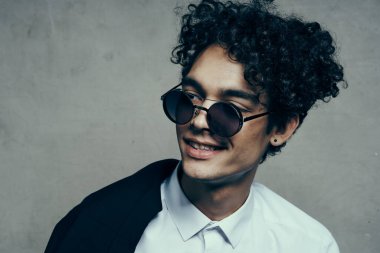 Gözlüklü mutlu adam. Kıvırcık saçlı. Gülümse.