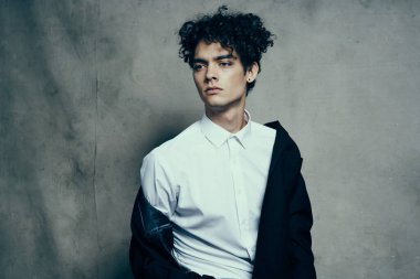 Beyaz gömlekli adam siyah ceketli moda stüdyosu manzaralı.