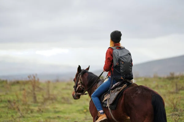 Woman hiker with backpack riding horse travel freedom — Stock Photo, Image