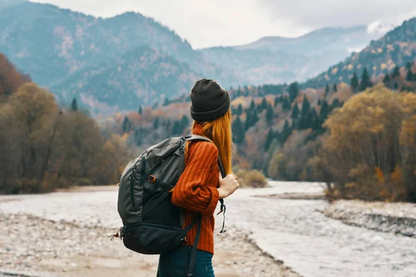 Mujer excursionista con una mochila de descanso en las montañas en la naturaleza cerca del río —  Fotos de Stock
