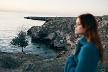 Dağlarda güzel bir kadın omuzlarında ekoseyle deniz ağacı modelinin yanında.