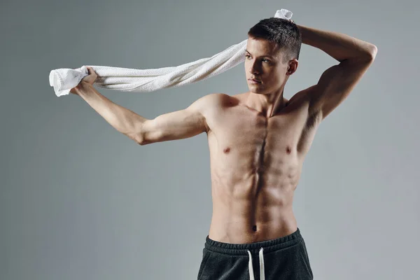 Sportivo uomo muscolare stampa asciugamani dietro la testa posa isolato sfondo — Foto Stock