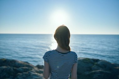 Turizm seyahati dağları manzaralı kadın deniz batımının yanındaki plajda