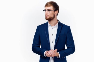 Mavi ceketli ve gözlüklü hafif gömlekli bir adam elleriyle hareket ediyor. 