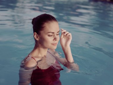 Havuzda kapalı gözlü güzel bir kadın. Yakın plan.