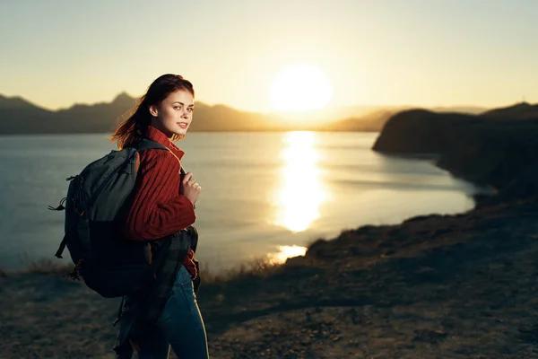 Жінка з рюкзаком на природі наші подорожі на заході сонця — стокове фото