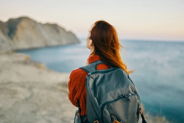 Donna viaggia con uno zaino vicino al mare in montagna nella natura — Foto Stock