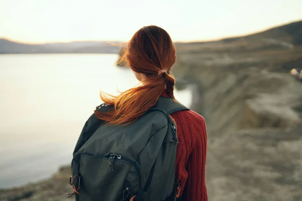 Portrait of woman with backpack on nature in the mountains near the sea at sunset cropped view — Stock Photo, Image