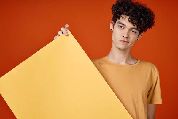복사 공간 을 광고하는 곱슬머리노란 포스터를 손에 든 남자 — 스톡 사진