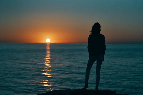 Mujer al atardecer silueta de mar en la orilla — Foto de Stock