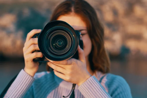 Rothaarige Frau mit Kamera auf die Natur in den Bergen am Fluss — Stockfoto