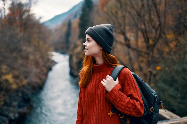 Mujer mochilero turístico en el puente cerca del río montañas bosque de otoño —  Fotos de Stock