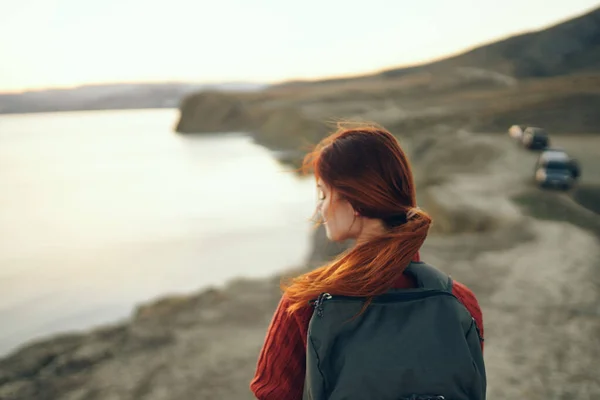 Bella donna in maglione con zaino sulla schiena sorriso turismo mare natura — Foto Stock