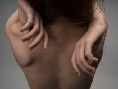 Kızıl saçlı, seksi bir kadının elleriyle sırtına dokunuşunun arka planı.
