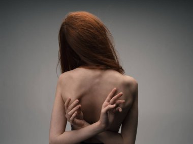 Elleri arkadan sarılmış bir kadın. Çıplak arka model.