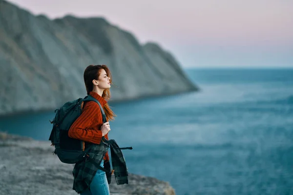 Подорож з рюкзаком в горах на відкритому повітрі дивиться на море червоний светр джинси модель — стокове фото