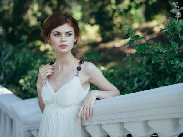 Γυναίκα σε λευκό φόρεμα glamor φρέσκο αέρα πράσινα φύλλα με τα πόδια μοντέλο — Φωτογραφία Αρχείου