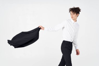  Klasik takım elbiseli genç bir adam. Elinde parlak bir arkaplan olan bir ceket. 