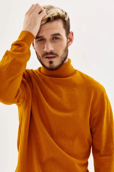 Knappe man houdt zijn hand op zijn hoofd mode herfst kleding studio — Stockfoto