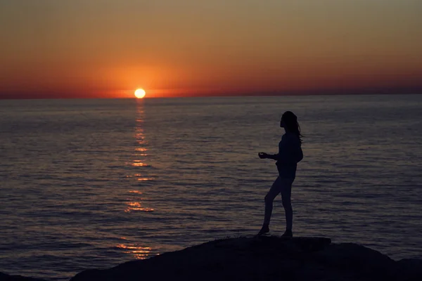 Silhouette of a woman by the sea in the mountains in nature — Stock Photo, Image