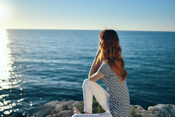 Woman on the sea in the mountains in the evening at sunset high cliffs mountains — Stock Photo, Image