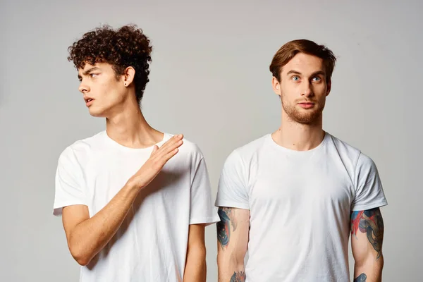 하얀 티셔츠를 입은 두 남자가 우정의 감정 옆에 서 있습니다 — 스톡 사진