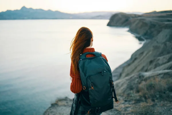 Un viaggiatore con uno zaino sulla schiena guarda il mare in lontane montagne paesaggio oceano acqua limpida — Foto Stock