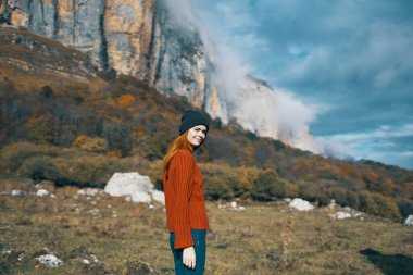 Doğa kadını, dağ turizmi modelinde kazak ve şapkayla seyahat eder.