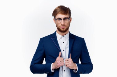 Klasik takım elbiseli bir işadamı başparmağını kaldırıyor. Çalışma ışık arka planında başarı.