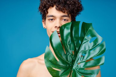 Çıplak adam yeşil yaprak açık ten mavi arka plan