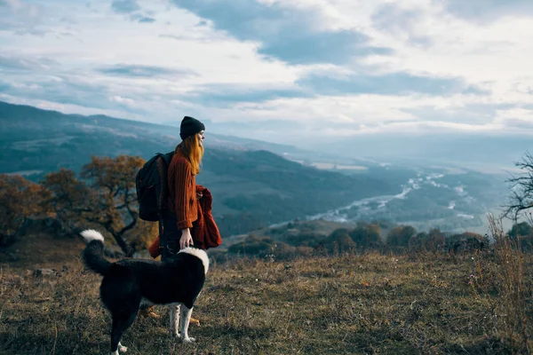 Mujer con mochila en la naturaleza al lado de perro paseo montaña paisaje —  Fotos de Stock